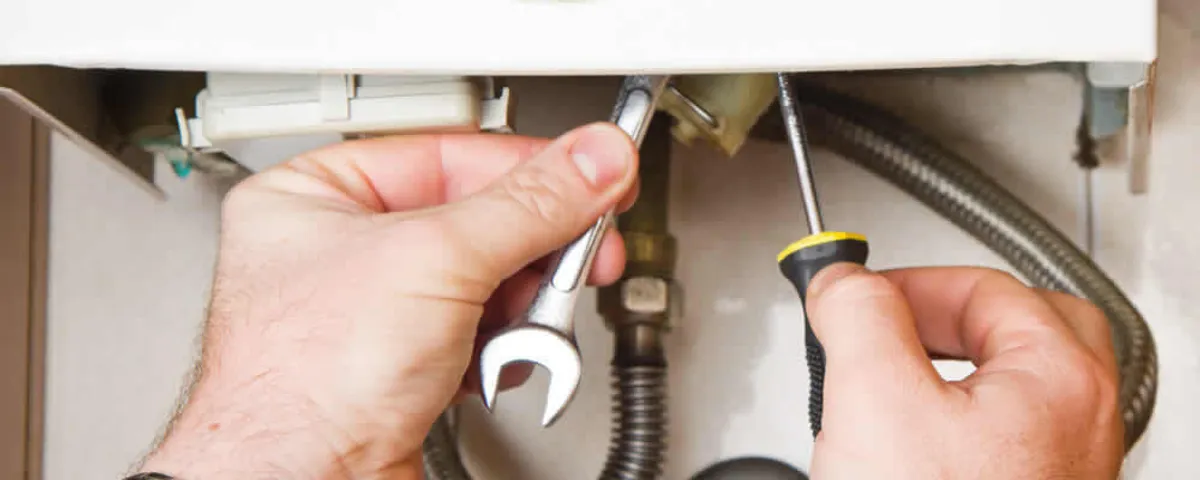 Boiler repair technician tightening pipe fittings and connections in Lafayette, LA