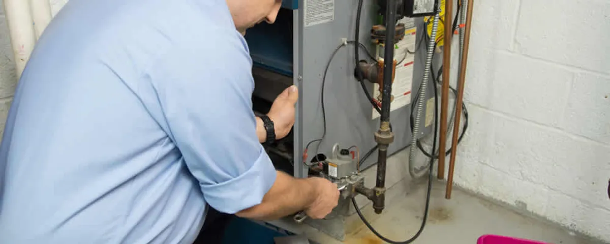 Furnace repair technician inspecting and servicing a home heating system in Lafayette, LA