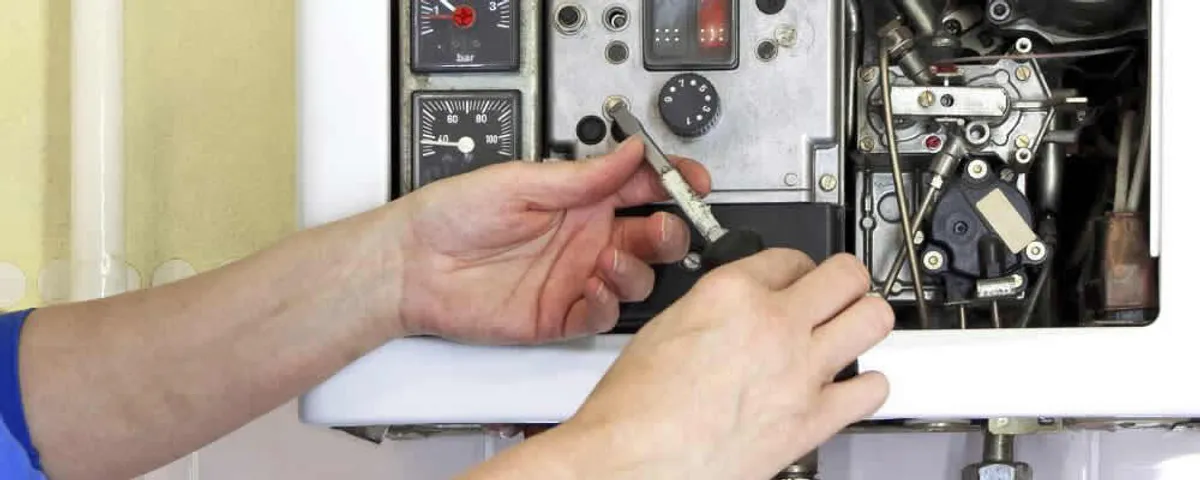 Heating repair technician adjusting boiler controls and components in Lafayette, LA
