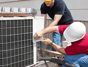 HVAC technicians repairing an outdoor AC unit on a rooftop in Lafayette, LA