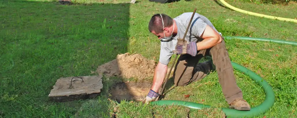 Septic pumping technician servicing a residential septic tank in Lafayette, LA