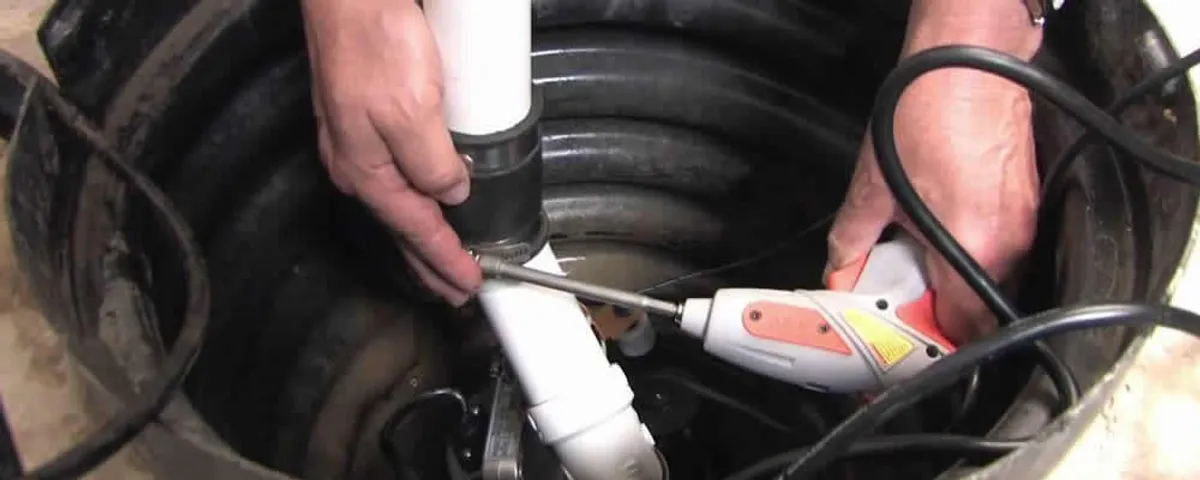 Sump pump installation technician connecting PVC discharge piping in Lafayette, LA