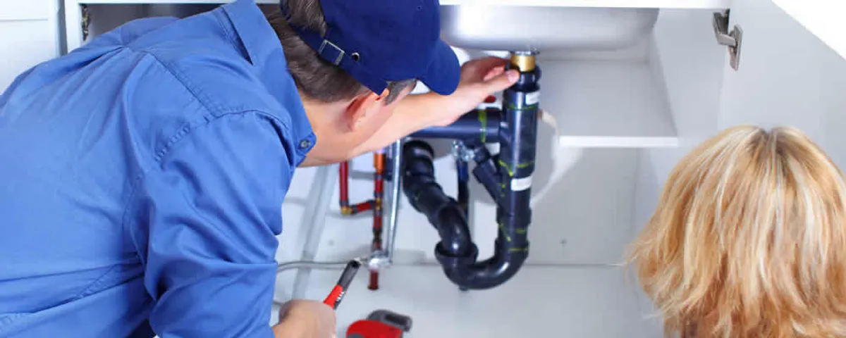 Plumber repairing under-sink drain pipes and fittings in Lafayette, LA